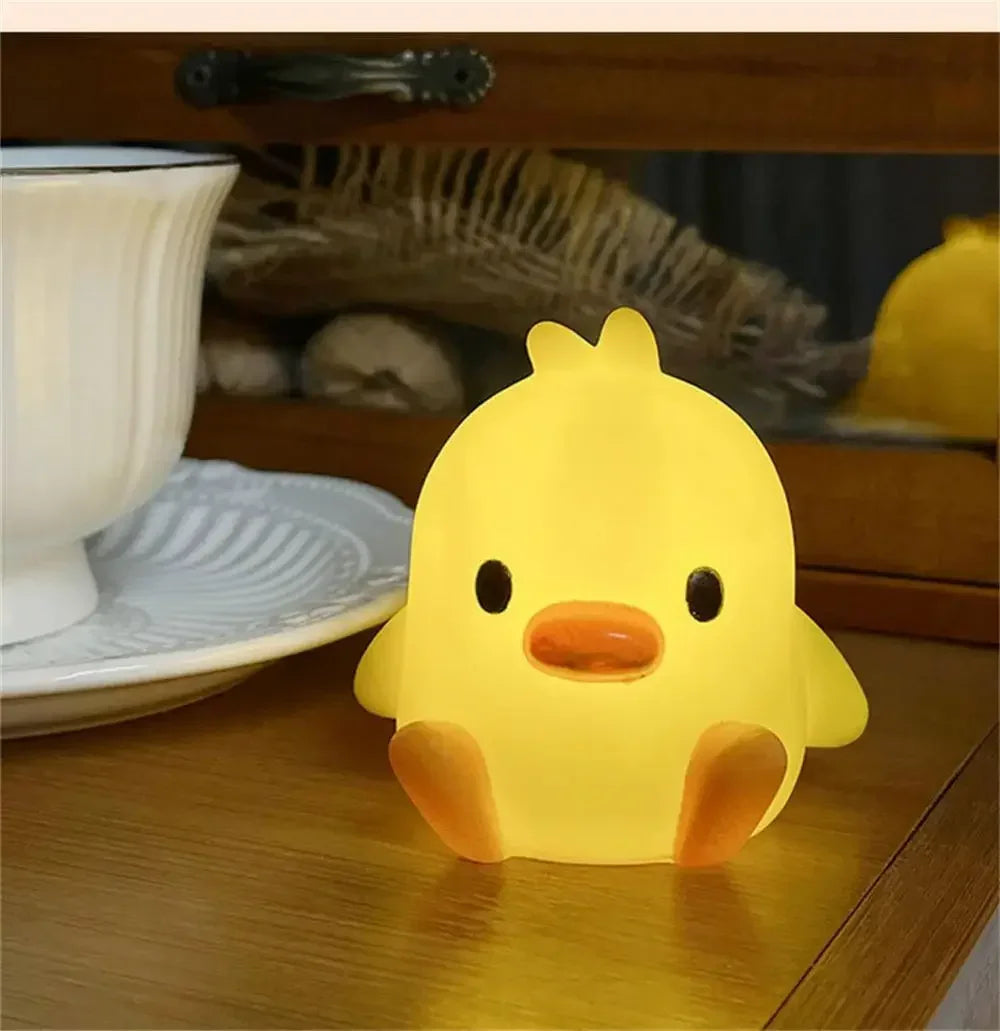 Yellow duck-shaped night light on a wooden surface with a blurred background