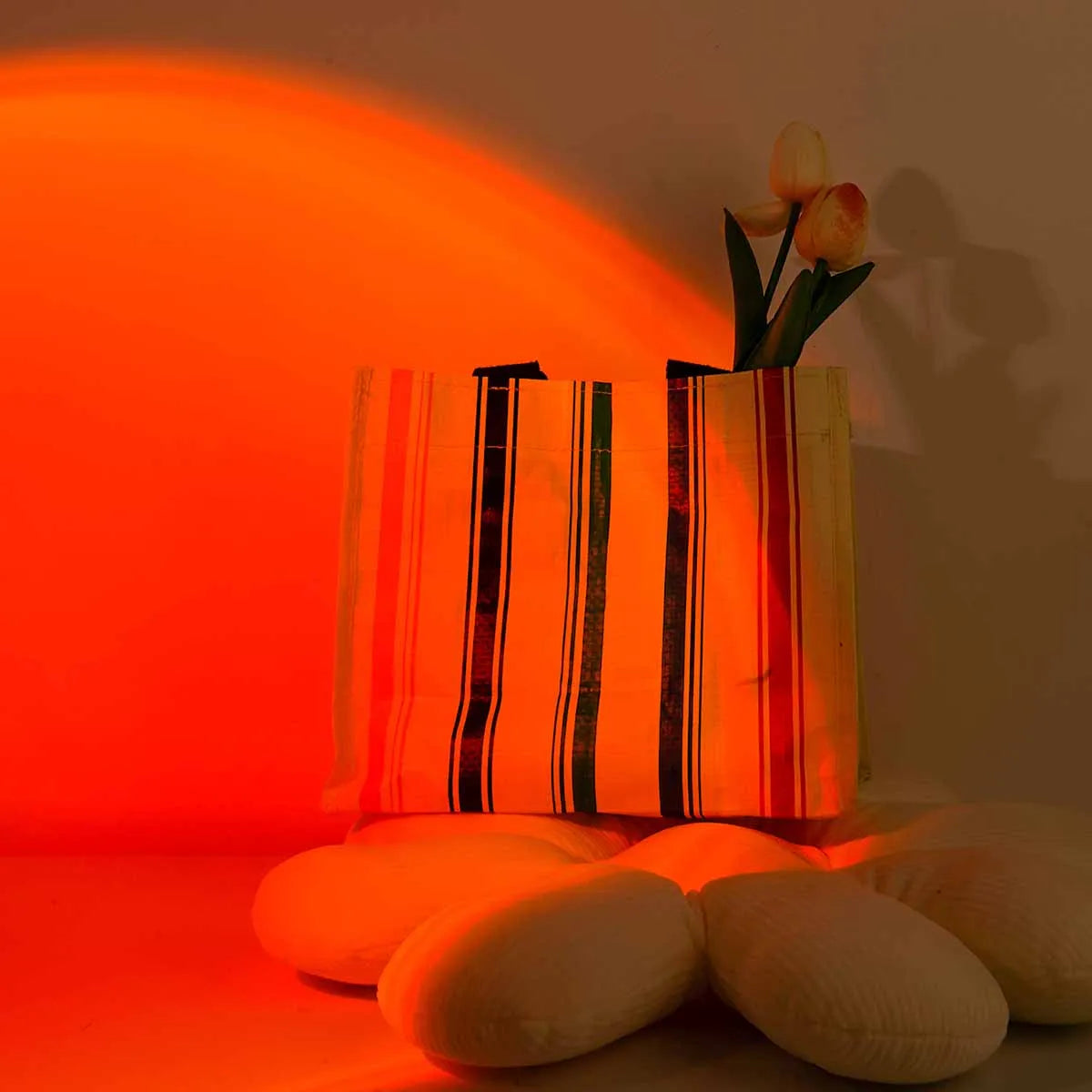 Vase with flowers on a table illuminated by a warm orange light